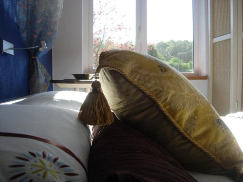 a couple of pillows on a couch with a window at Glan Llyn Farm House in Mold