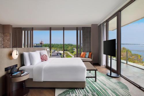 a bedroom with a large white bed and a large window at Hotel Indigo Suzhou Yangcheng Lake, an IHG Hotel in Suzhou