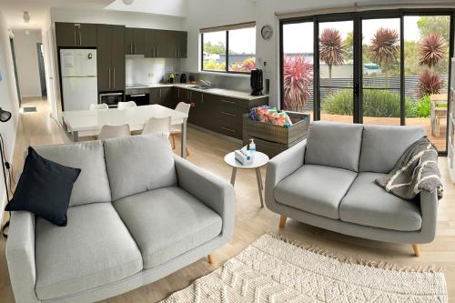 un salon avec un canapé et une cuisine dans l'établissement Fairways 1, à Coles Bay