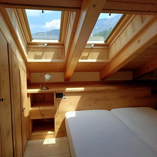 a small attic room with a bed and a window at Maso Margherita in Commezzadura
