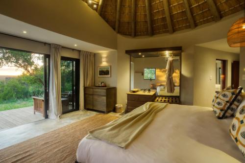 a bedroom with a large bed and a bathroom at Klaserie Drift Misava in Klaserie Private Nature Reserve