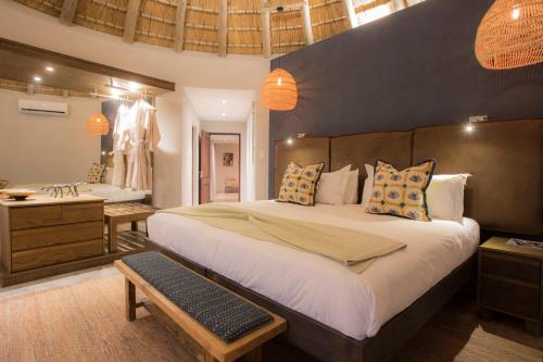 a bedroom with a large bed and a bathroom at Klaserie Drift Misava in Klaserie Private Nature Reserve