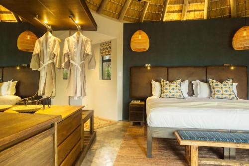 a bedroom with a bed and a dresser in a room at Klaserie Drift Misava in Klaserie Private Nature Reserve