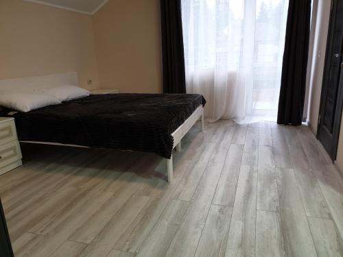 a bedroom with a bed and a wooden floor at Hotel Osher in Bukovel