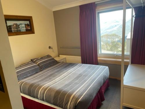 A bed or beds in a room at Cooroona Alpine Lodge