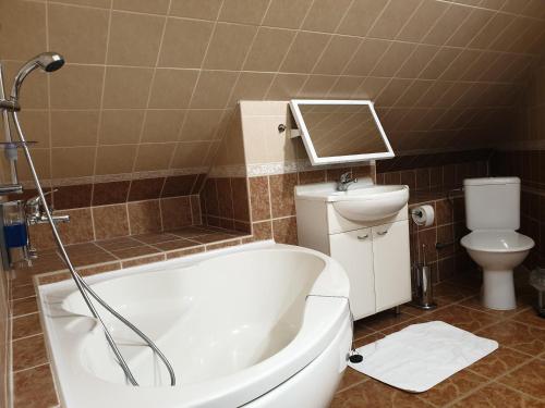 a bathroom with a bath tub and a toilet at Pribina Penzión in Nitra