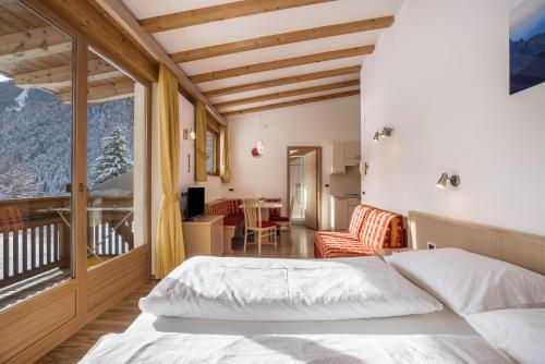 um quarto com uma cama e uma varanda em Runcac Apt Gomina em San Vigilio Di Marebbe