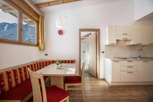 a kitchen and dining room with a table and chairs at Runcac Apt Gomina in San Vigilio Di Marebbe