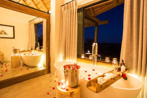 a bathroom with a tub and a sink and a bath tub at Klaserie Drift in Klaserie Private Nature Reserve