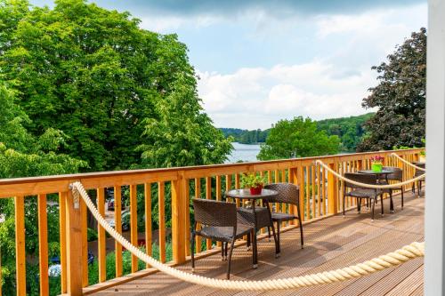 a deck with chairs and tables and a rope at Hotel Holsteinische Schweiz am Dieksee in Malente