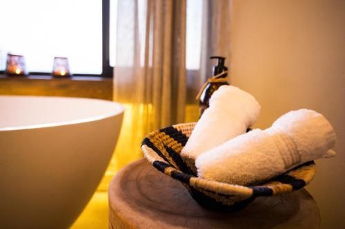 a bathroom with a basket with towels on a table at Klaserie Drift Misava in Klaserie Private Nature Reserve