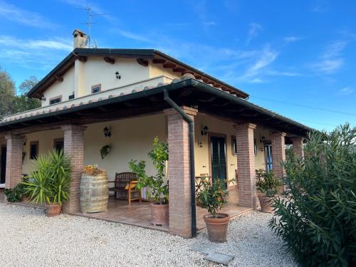 a house with a porch with a patio at Casale Terre Rosse Garden in Saturnia