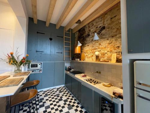 uma cozinha com armários azuis e um piso xadrez em B&B Tholen t’Uusje em Tholen