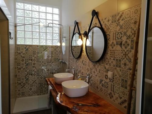 a bathroom with two sinks and a mirror at Granny's farm in São Vicente