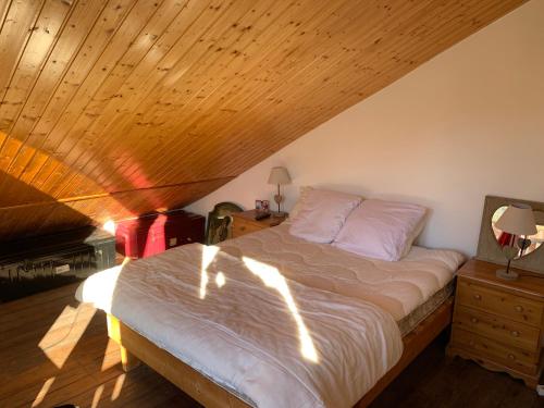 a bedroom with a bed and a wooden ceiling at Chalet Auris in Auris