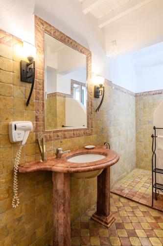 a bathroom with a sink and a mirror at Pelican Bay Hotel in Platis Yialos Mykonos