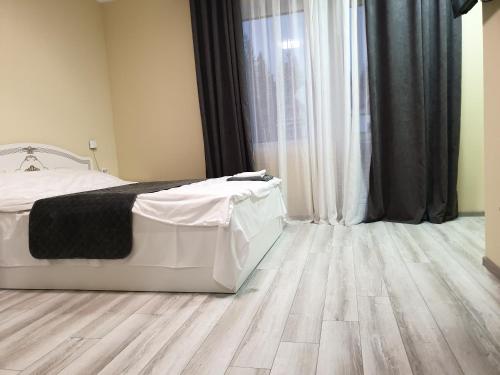 a bedroom with a bed and a wooden floor at Hotel Osher in Bukovel