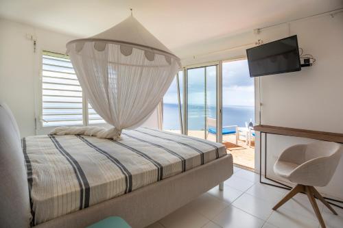 a bedroom with a bed and a view of the ocean at JOULOUKA in Trois-Rivières