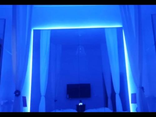 a mirror in a bedroom with a blue light at Babbo maison in Guidonia