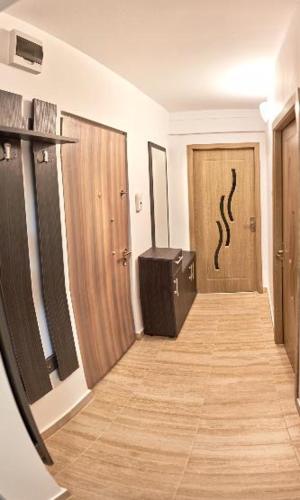 Pokój z korytarzem z dwoma drewnianymi drzwiami w obiekcie Apartament 2 camere cu loc de parcare w Klużu-Napoce