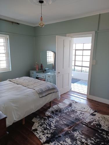 ein Schlafzimmer mit einem Bett und einem Spiegel in der Unterkunft Yardley Cottage in Colesberg