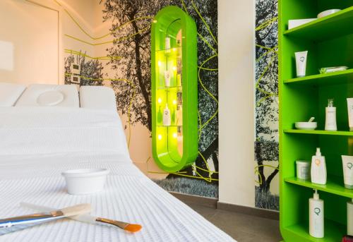 a room with a white bed and green shelves at Grand Hotel Ambasciatori Wellness & Spa in Chianciano Terme