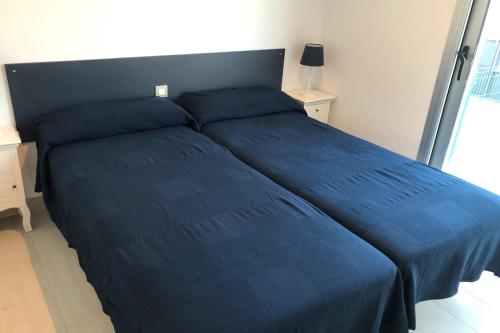 a blue bed in a bedroom with a blue bedspread at Martormar in Finestrat