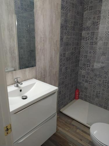 a bathroom with a white sink and a toilet at Casa el Anden 11 in El Bosque