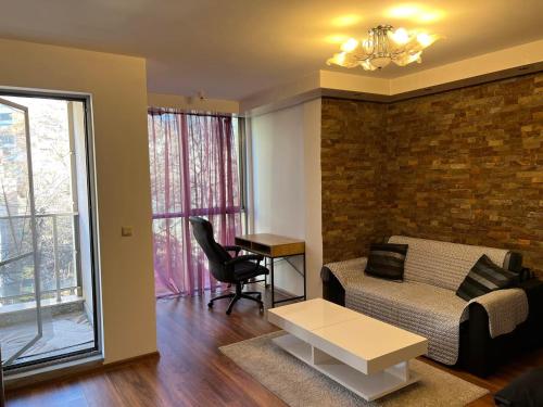 a living room with a couch and a table at Nice and cozy flat in the center in Sofia