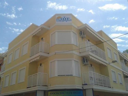 a yellow building with a sign on top of it at Apartamentos Margoysa I in Los Alcázares