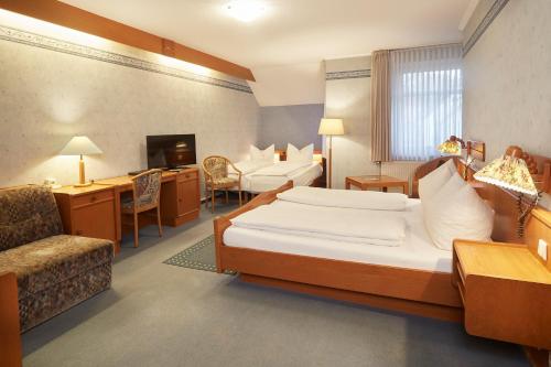 a hotel room with a bed and a desk and a chair at Park Hotel Berlin in Bad Fallingbostel