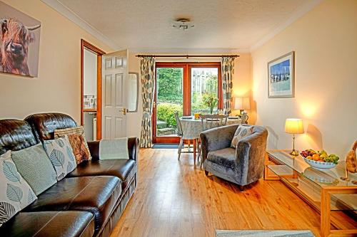 a living room with a couch and a table at Charming Cottage near Cartmel with free Spa access in Holker