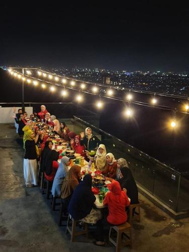 a group of people sitting at a long table at night at Roemah Asri Villa - Resor Dago Pakar in Bandung