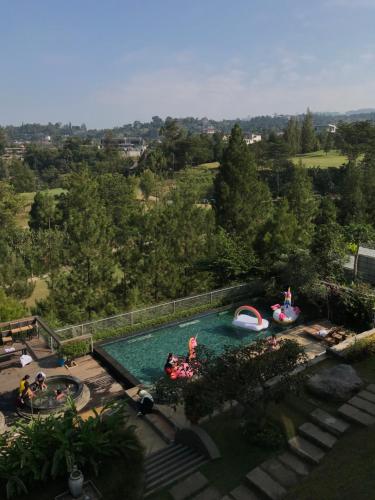 une vue aérienne sur une piscine avec deux gonflables dans l'établissement Roemah Asri Villa - Resor Dago Pakar, à Bandung