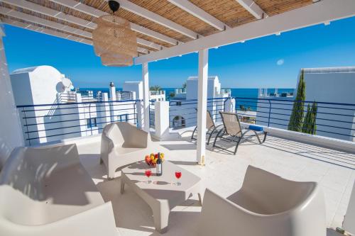 balcón con muebles blancos y vistas al océano en Villa Saint Nikolas, en Protaras