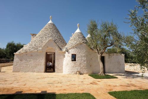 a stone church with a tree in front of it at Trullo Due Ulivi in Monopoli