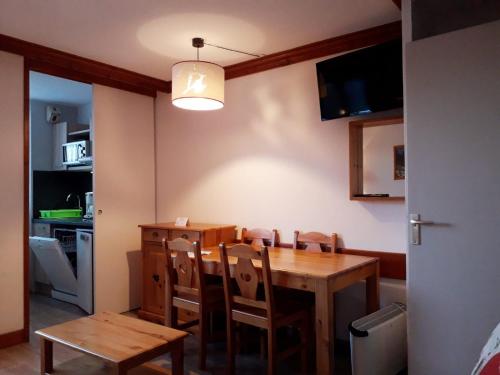 uma sala de jantar com uma mesa de madeira e cadeiras em Creux de l'Ours Mottaret, 3 à 5 couchages em Méribel