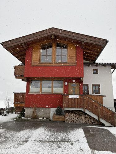 a house covered in snow in front at Ferienwohnung Magdalena in Stumm