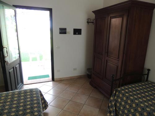 a bedroom with a bed and a closet and a door at Agriturismo Valle Martina in Saturnia