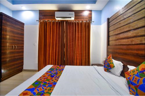 a bedroom with a bed and a wooden wall at FabHotel Ocean View Apartment - Nr Dabolim Airport in Old Goa