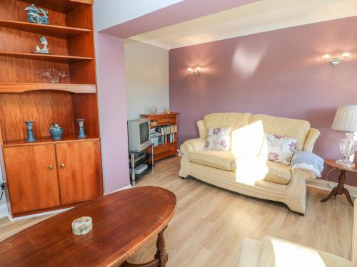 a living room with a couch and a table at Lavender Cottage in Castletownbere
