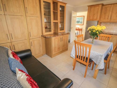 a kitchen and dining room with a table and a couch at Lavender Cottage in Castletownbere
