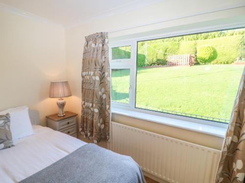a bedroom with a window with a view of a yard at Lavender Cottage in Castletownbere