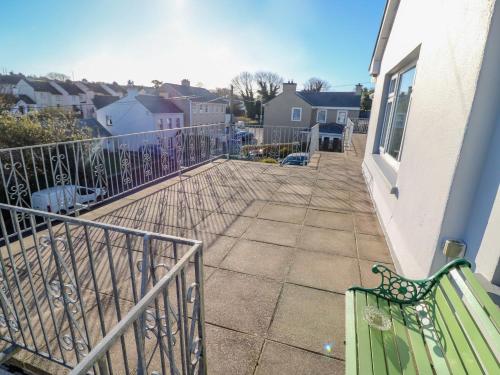 a balcony of a house with a green bench at Lavender Cottage in Castletownbere