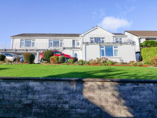 a house with a retaining wall in front of a yard at Lavender Cottage in Castletownbere