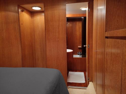 a bedroom with a bed and a bathroom with a sink at BOAT & BREAKFAST LUCRETIA, LUXURY yacht in Àrbatax