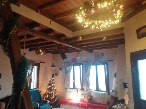 a living room with a christmas tree and a chandelier at Cycladic House in Vari
