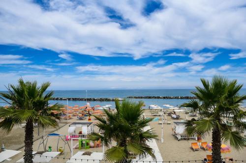 a view of a beach with palm trees and the ocean at Baldinini Hotel in Rimini