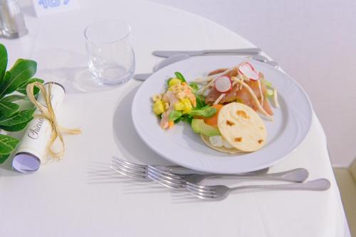 a plate of food on a white table with silverware at Hotel Cristallo in Riccione