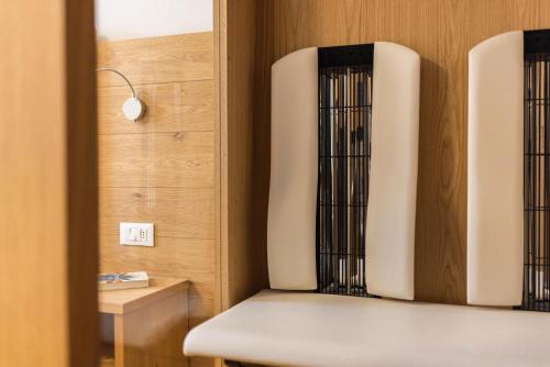 a room with a bench and a wall with a lightswitch at Rosalpina Apt 4 in San Vigilio Di Marebbe